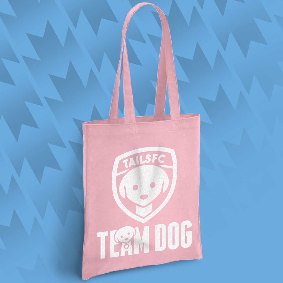 Pink tote bag with 'TAILSFC Team Dog' design on a blue geometric patterned background