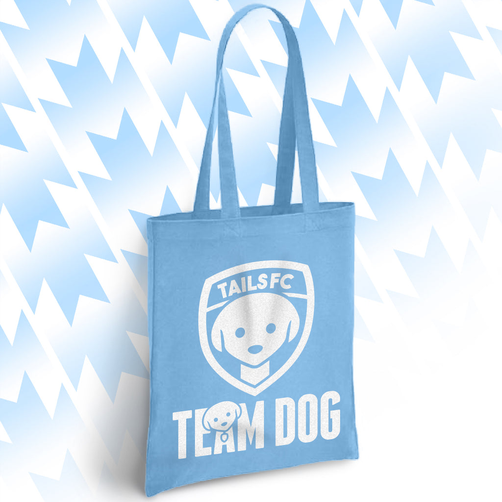 Light blue tote bag with 'TAILSFC Team Dog' design on a light blue abstract background