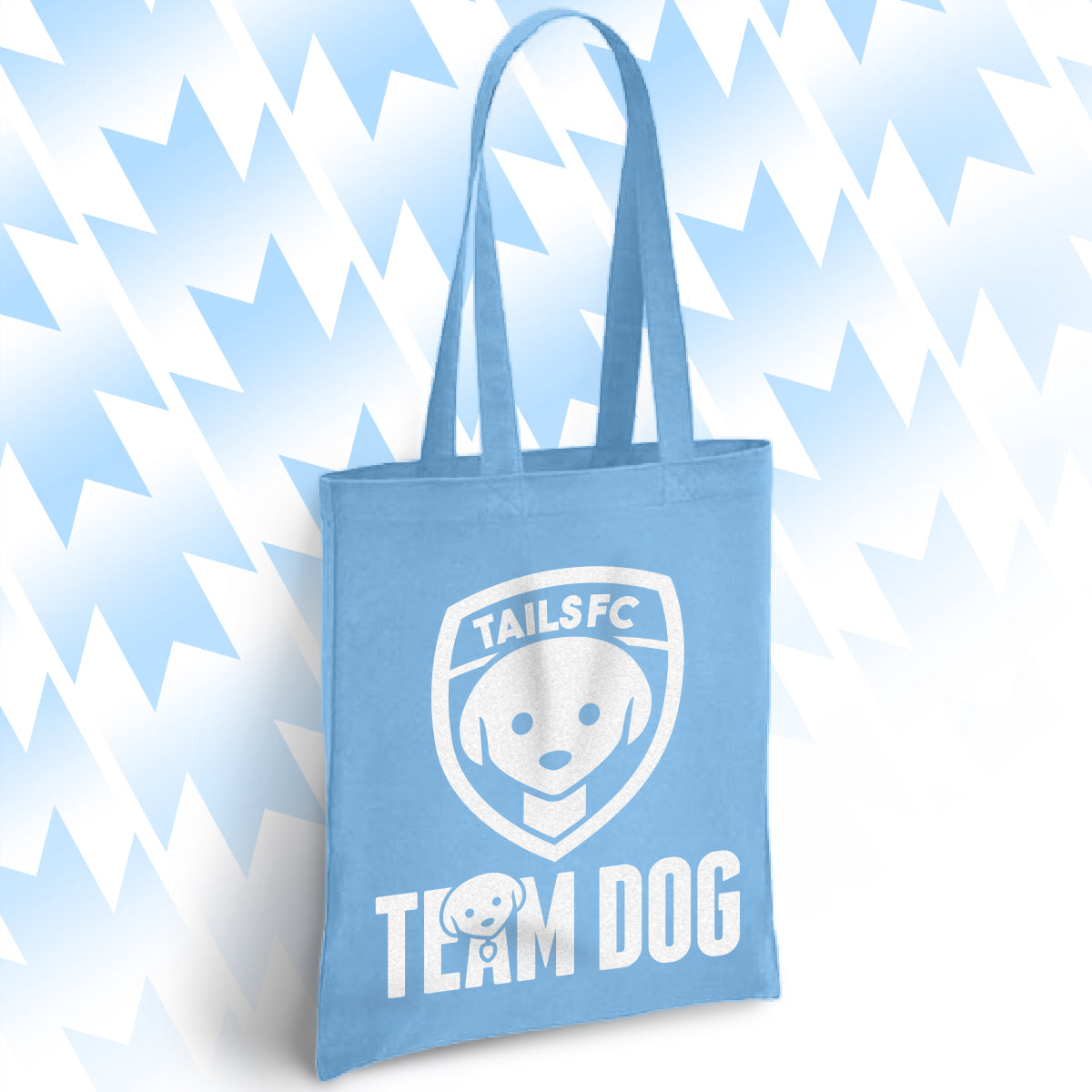 Light blue tote bag with 'TAILSFC Team Dog' design on a light blue abstract background