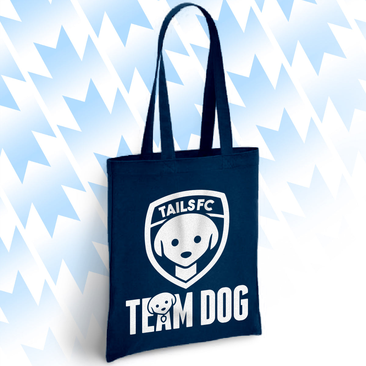 Navy blue tote bag with 'TAILSFC Team Dog' logo on a light blue abstract background