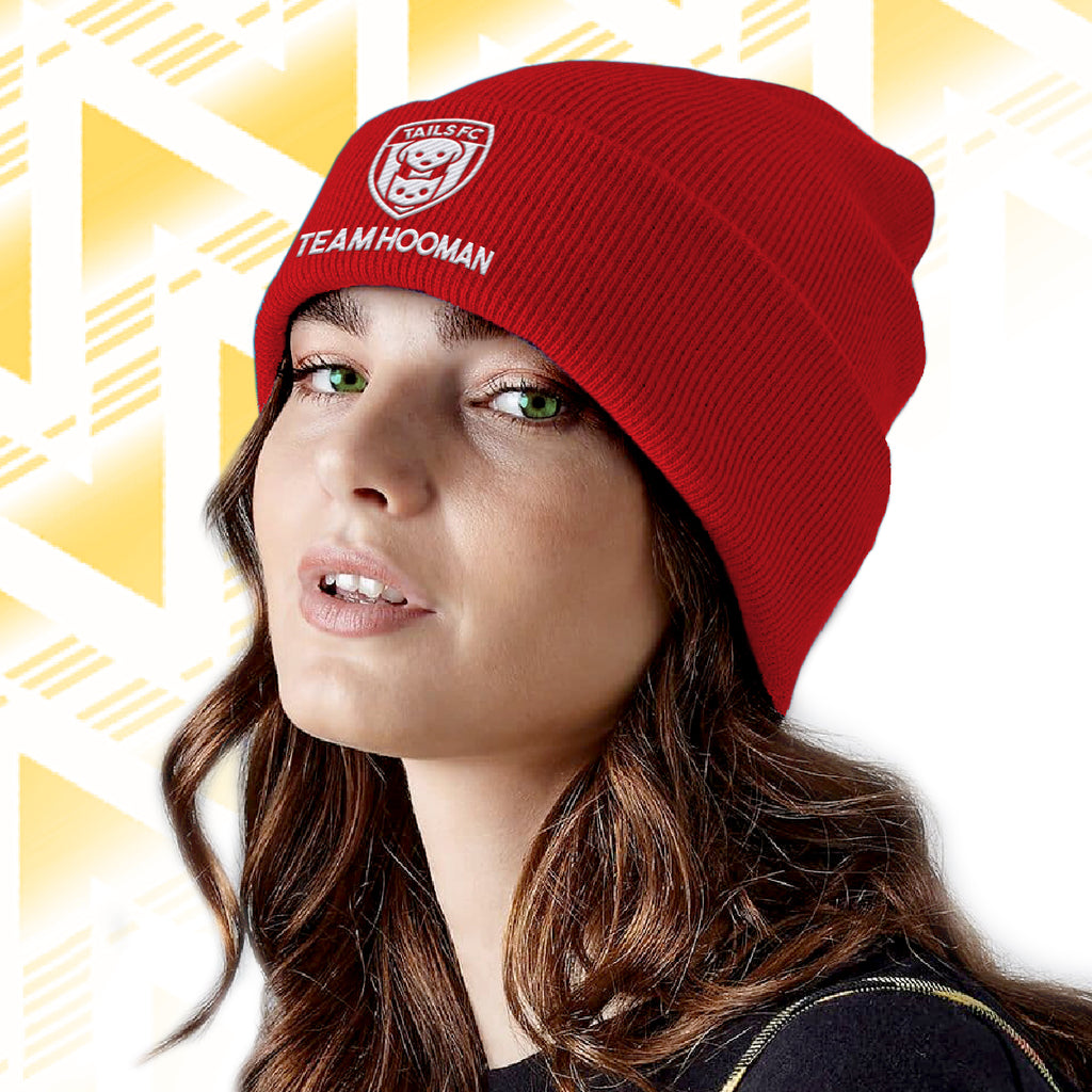 Person wearing a red beanie with 'Team Hooman' text against a geometric patterned background