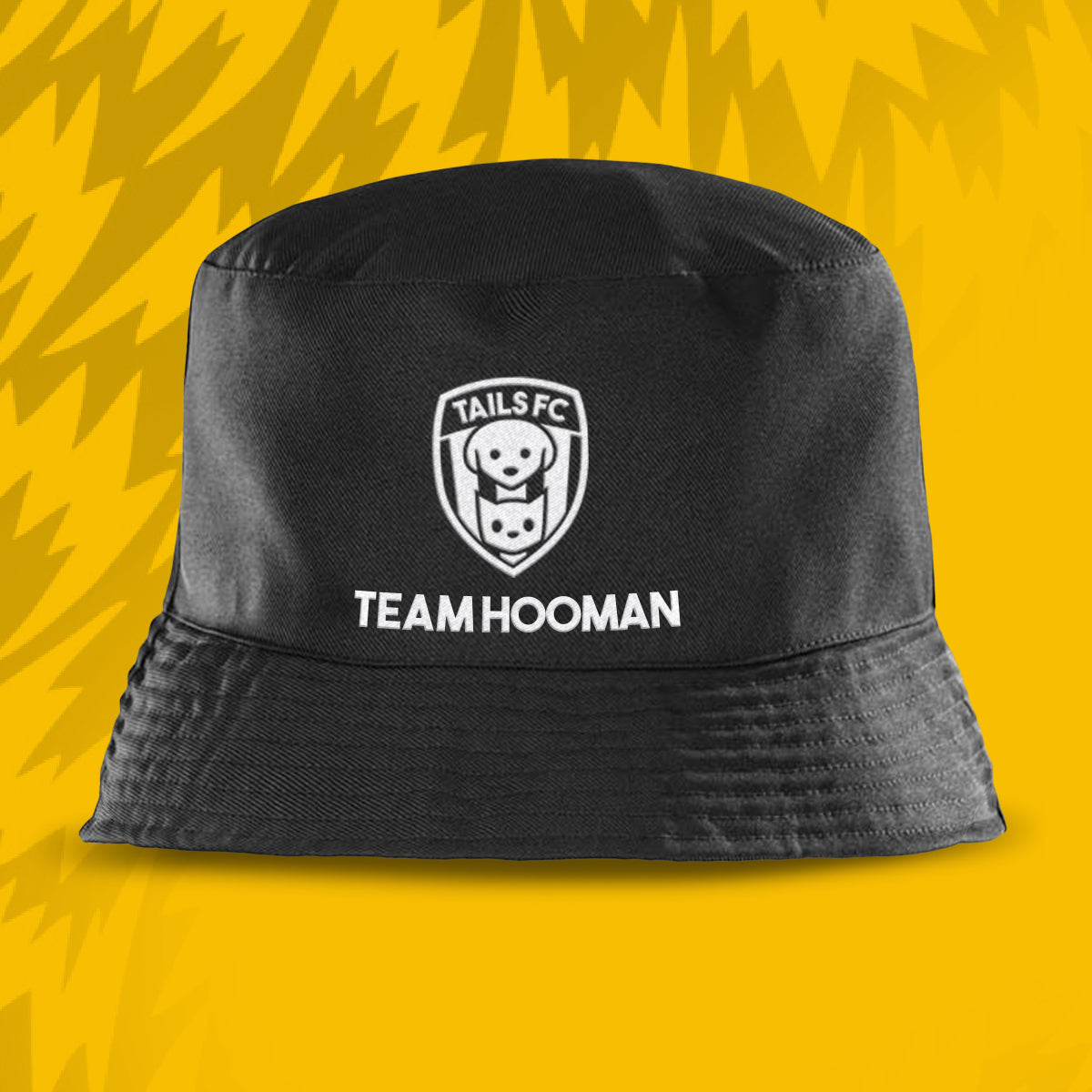 Black bucket hat with 'Tails FC' logo and 'Team Hooman' text on a yellow background