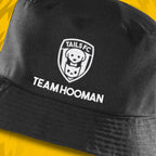 Black cap with 'TAILS FC' logo and 'TEAM HOOMAN' text on a yellow background