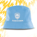 Blue bucket hat with 'Tails FC' and 'Team Hooman' text on a white background with yellow abstract patterns.