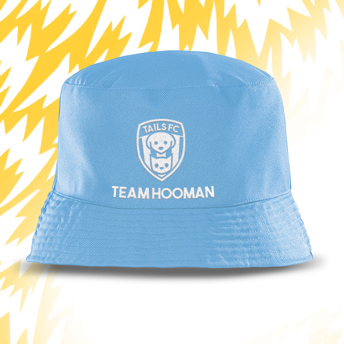Blue bucket hat with 'Tails FC' and 'Team Hooman' text on a white background with yellow abstract patterns.