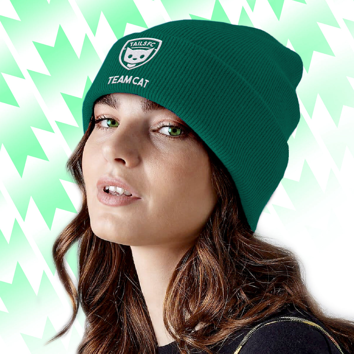 Person wearing a green beanie with Tails FC 'Team Cat' logo and text against a light green and white geometric patterned background