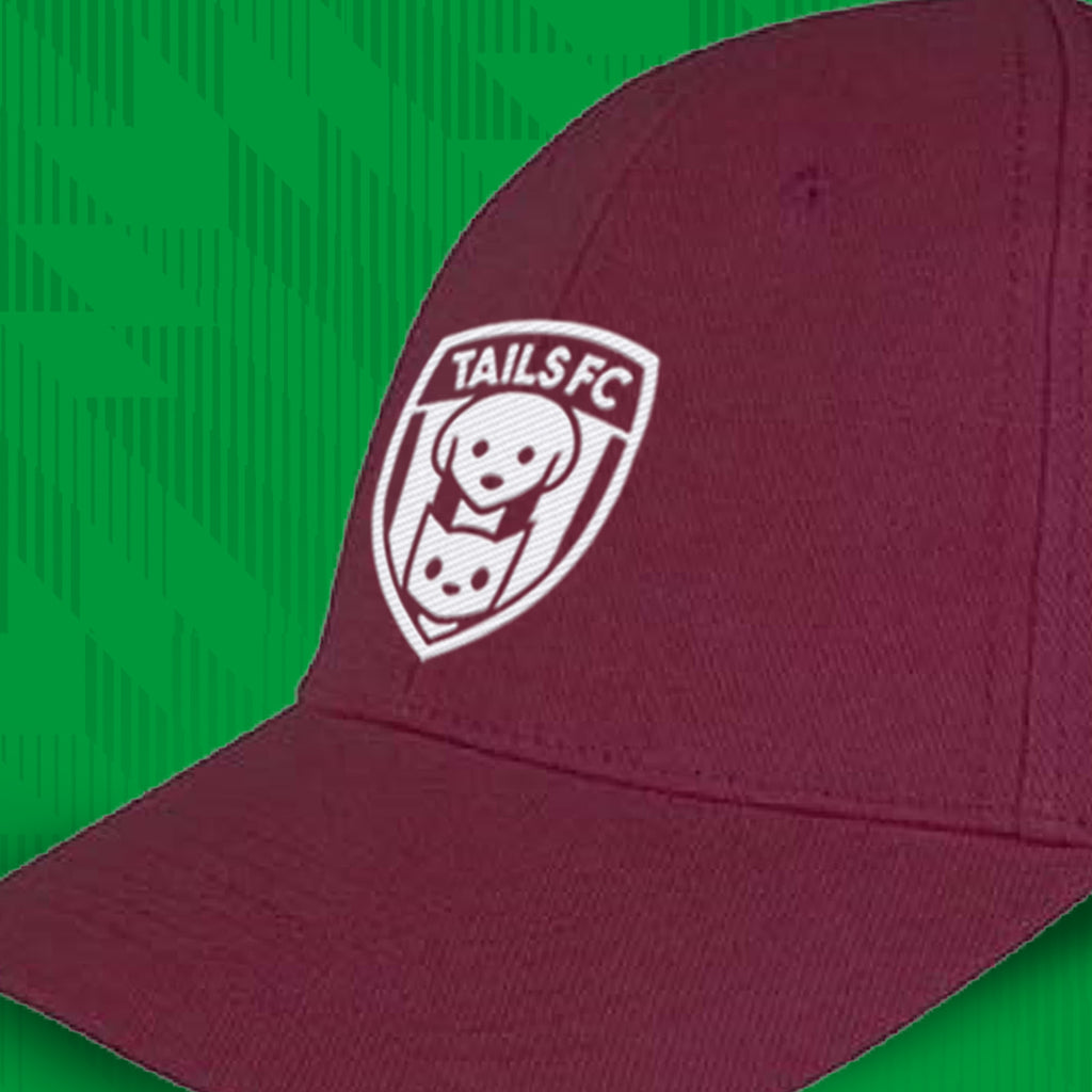 Maroon cap with TAILS FC logo on a green background