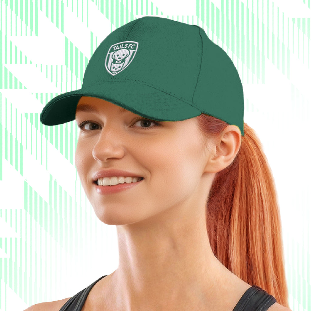 Woman wearing a green cap with Tails FC  logo on a white background