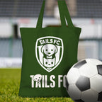 Green tote bag with 'TAILS FC' logo on grass with a soccer ball